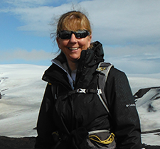 Headshot of Adele at the peak of a mountain