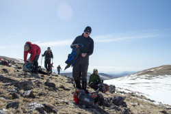 Team member Craig heading to grab his pack after the team takes a break on some rocky terrain. Photo Credit: Rob Jackson