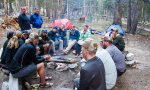 group of people sitting around a campfire